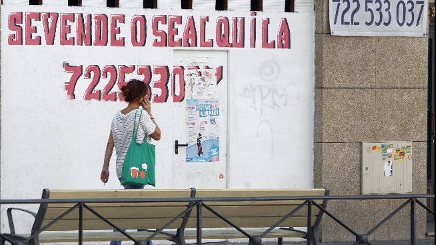 Una mujer pasa ante un inmueble en alquiler