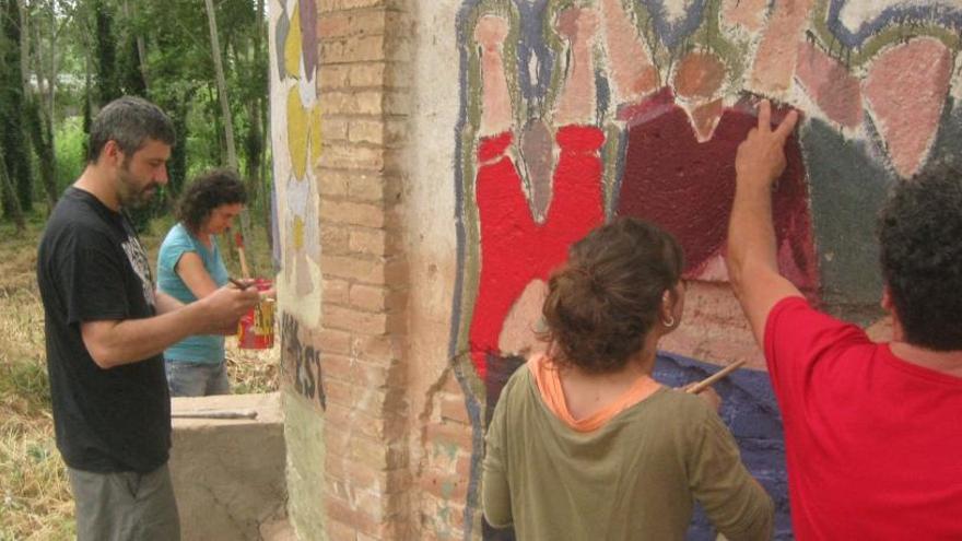 Participants en la jornada pintant el pou