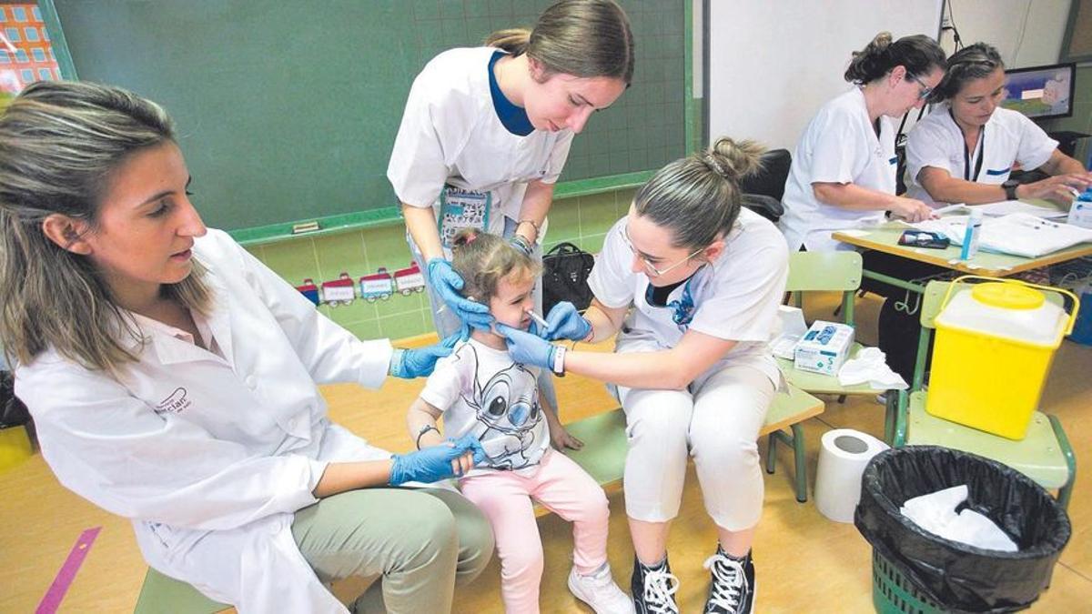 Enfermeras vacunan a niños con la dosis intranasal en un colegio de Zarandona.