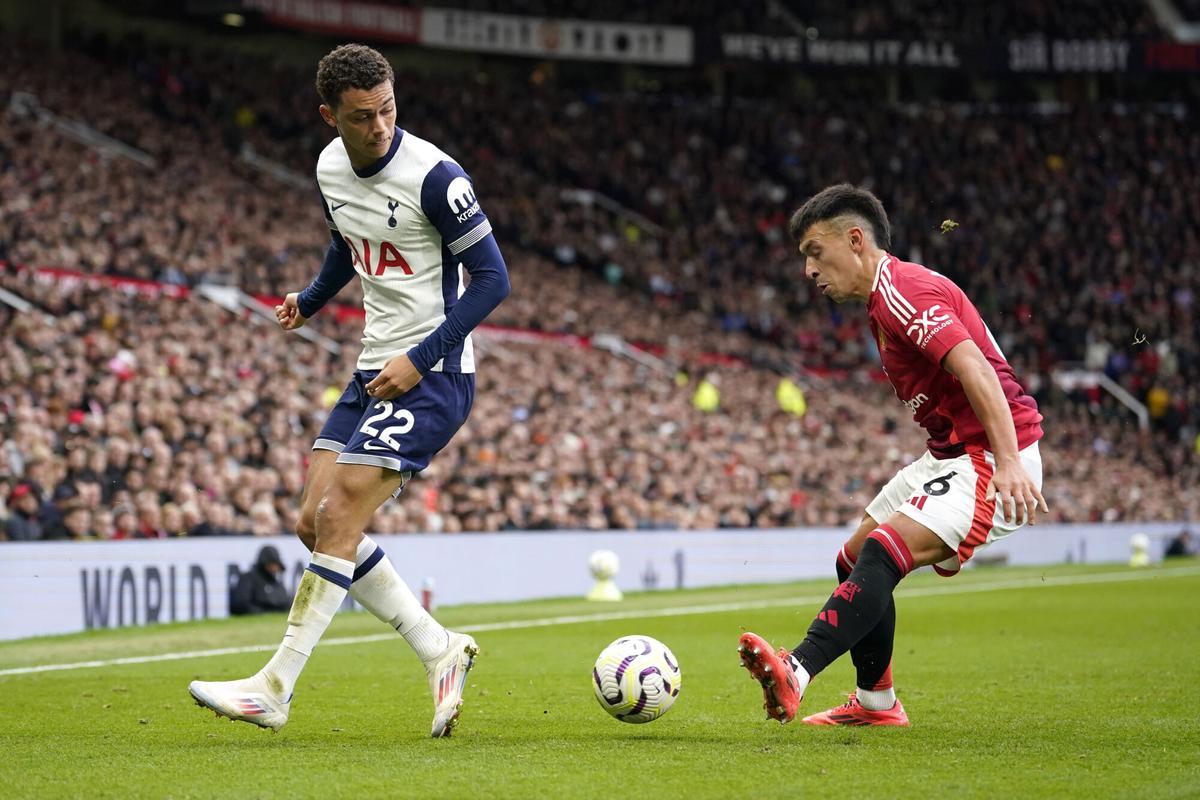 Manchester United's Lisandro Martinez, right, kicks the ball ahead of Tottenham's Brennan Johnson during the English Premier League soccer match between Manchester United and Tottenham Hotspur at Old Trafford stadium in Manchester, England, Sunday, Sept. 29, 2024. (AP Photo/Dave Thompson)