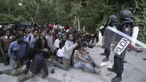 Inmigrantes retenidos tras saltar la valla en Ceuta el pasado febrero.