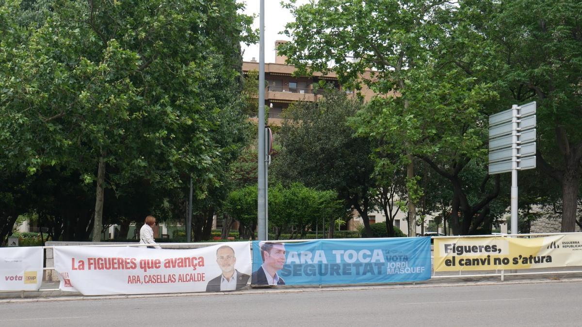 Pancartes electorals penjades en una tanca de l'avinguda Salvador Dalí de Figueres, davant dels Jardins Enric Morera
