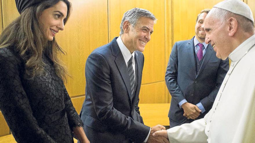 George Clooney y su mujer, Amal Ramzi, saludan ayer al Papa en el Vaticano.