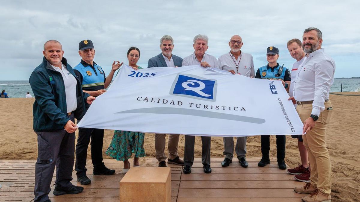 El concejal Pedro Quevedo sostiene la bandera de ‘Q Calidad Turística’.