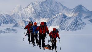 El científico chileno Ricardo Jana (2-i) y un grupo de exploradores militares rastrean un área con GPS cerca de Higgins Nunatak en el Glaciar Unión, situado en las montañas Ellsworth, en la Antártida, el 29 de noviembre de 2018.