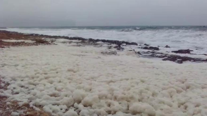 El temporal marítimo llena de espuma la Cala Blanca de Xàbia