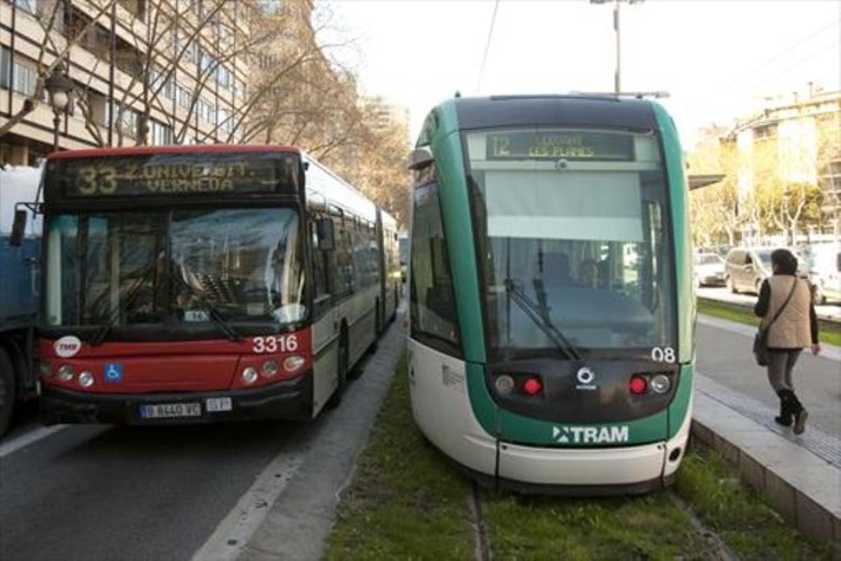 Un tramvia del Trambaix al final del trajecte, a la plaça de Francesc Macià, al costat d’un autobús urbà.