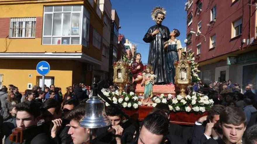 San Juan Bosco, sobre los hombros de chicos jóvenes.