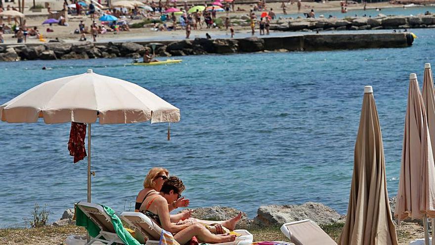 Dos mujeres toman el sol en la playa de Figueretes. | VICENT MARÍ