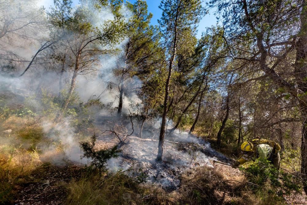 Los bomberos trabajan para sofocar un incendio en el parque de Serra Gelada