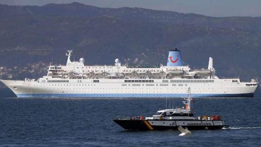 El &quot;Thomson Spirit&quot;, escoltado por una patrullera de la Guardia Civil, ayer, navegando por la Ría.  // J.S.