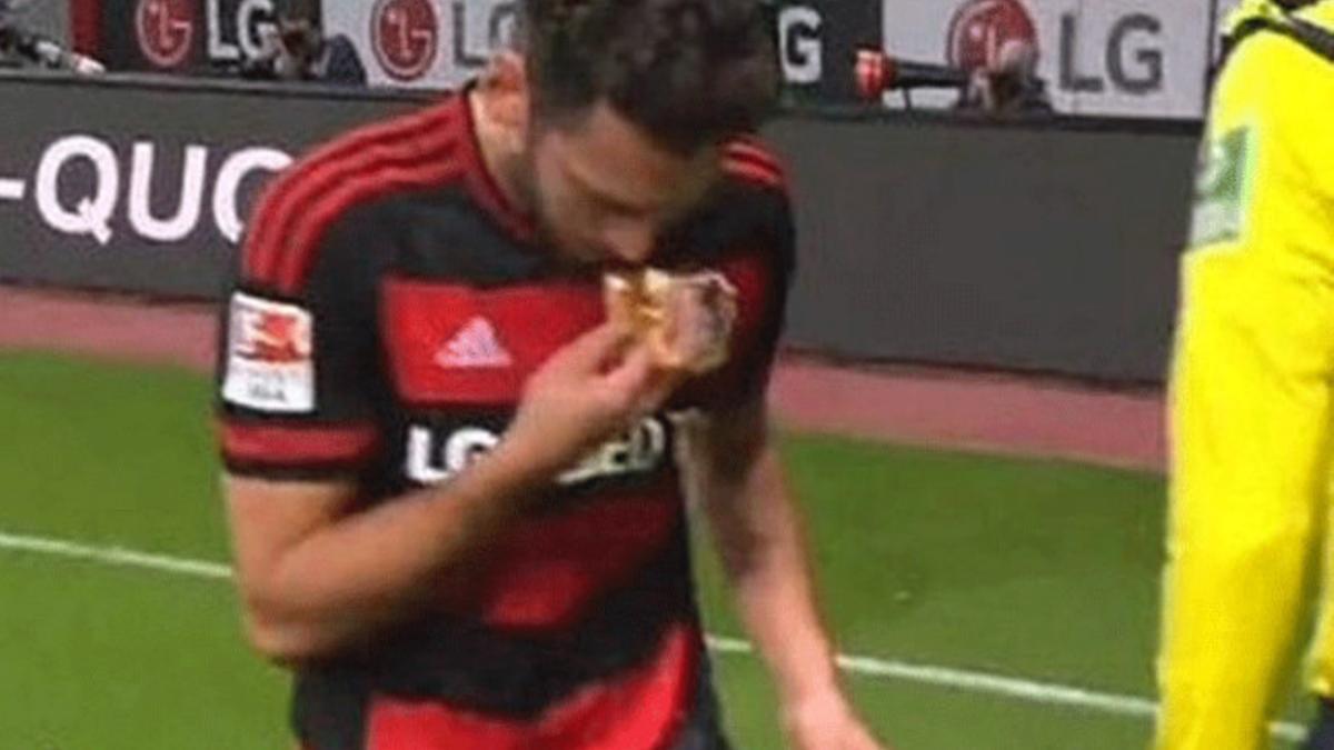 Çalhanoglu besa un trozo de comida que le lanzaron en el partido contra el Schalke