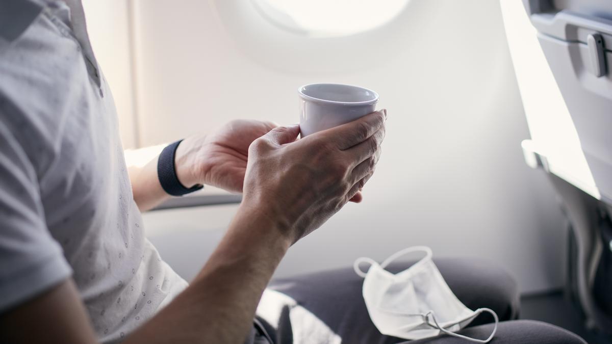 Un pasajero se toma un café a bordo de un avión