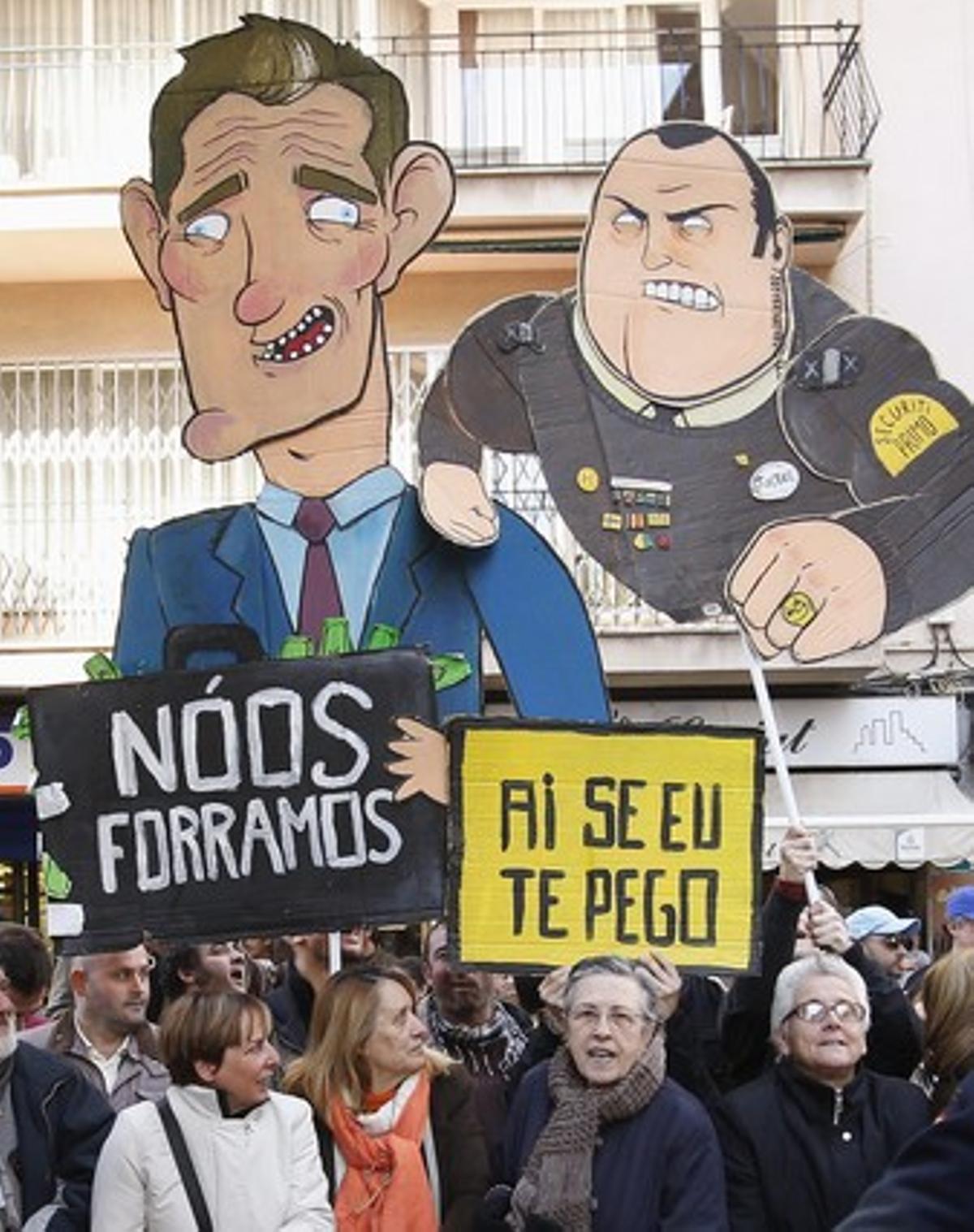 Los antimonárquicos muestran carticaturas durante la protesta.