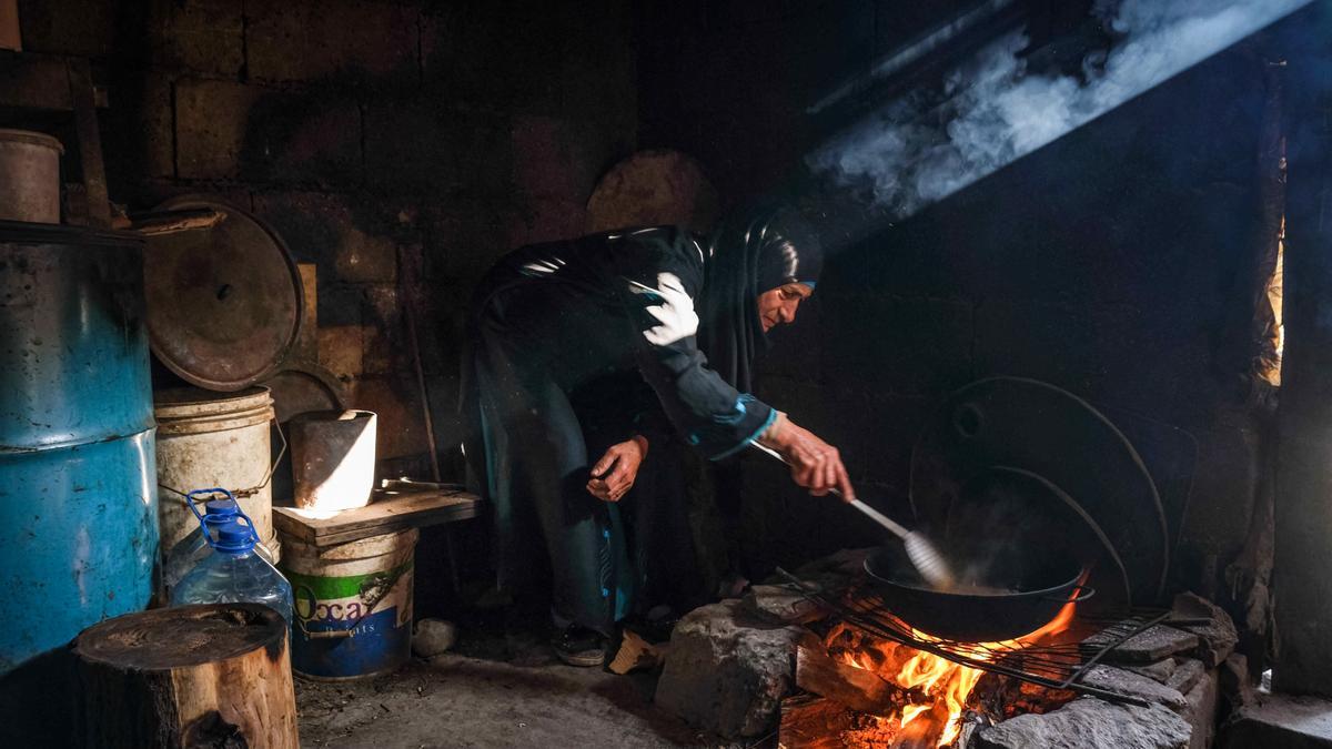 Una mujer fríe patatas en su vivienda en el barrio marginal construido junto al cementerio de Ghoraba, en Trípoli.