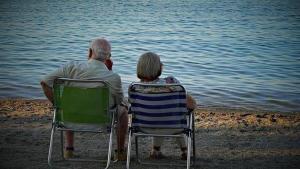 Una pareja de jubilados descansa en la playa.