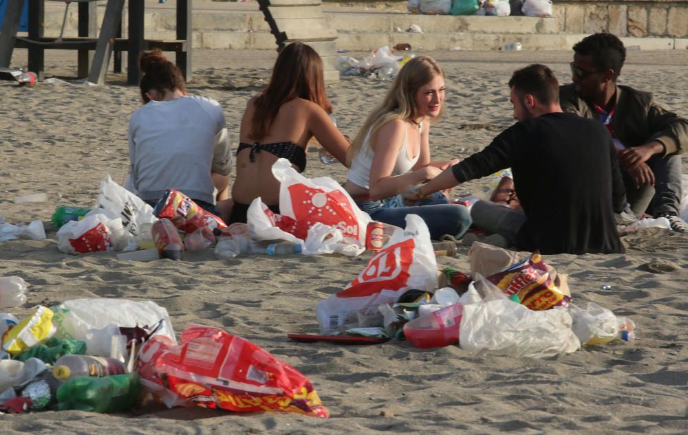 Los operarios de los servicios de limpieza trabajan para dejar la playa en óptimas condiciones tras una larga noche de fiesta en la arena