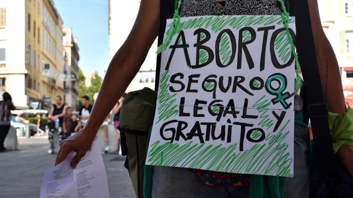 Una mujer camina con una pancarta en favor del aborto.