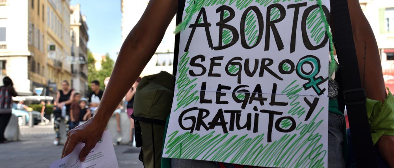 Una mujer camina con una pancarta en favor del aborto.