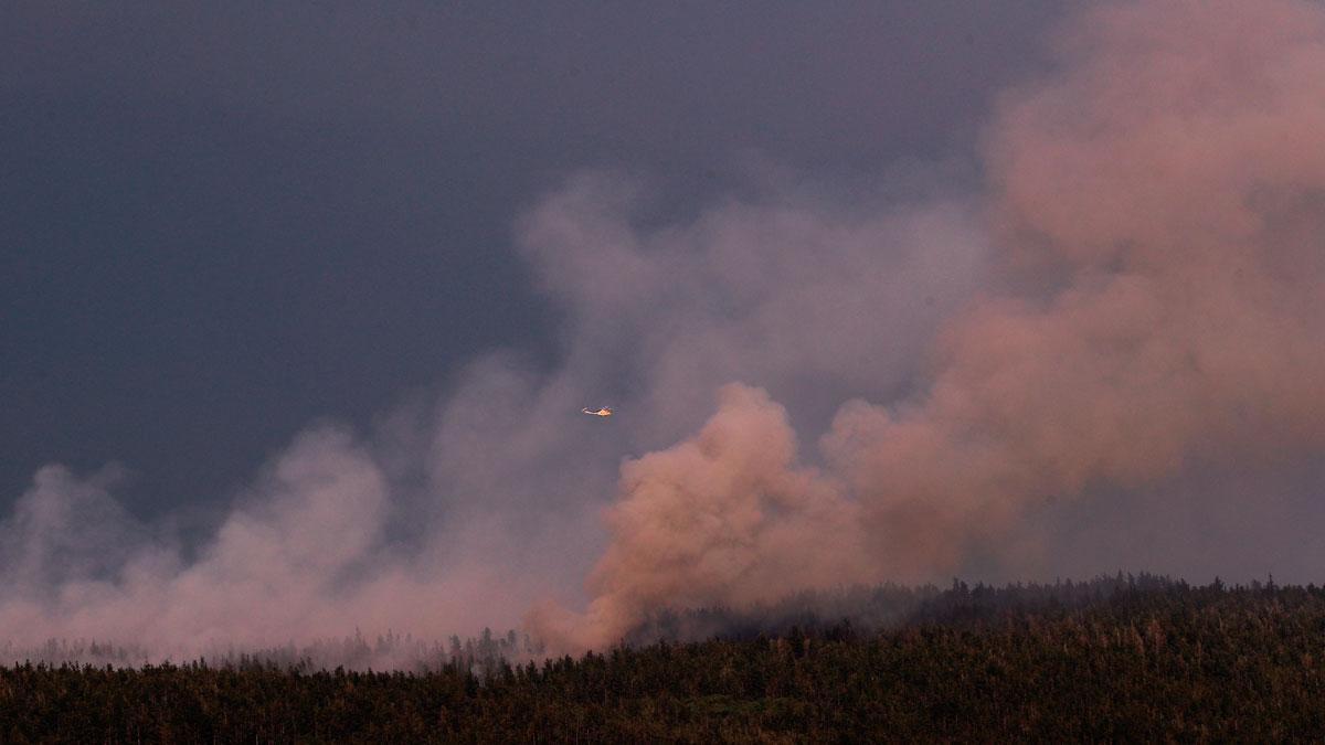 Un helicóptero combate las llamas en Guntín.