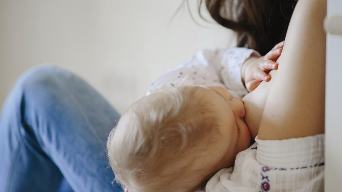 Una mujer da el pecho a su hijo.