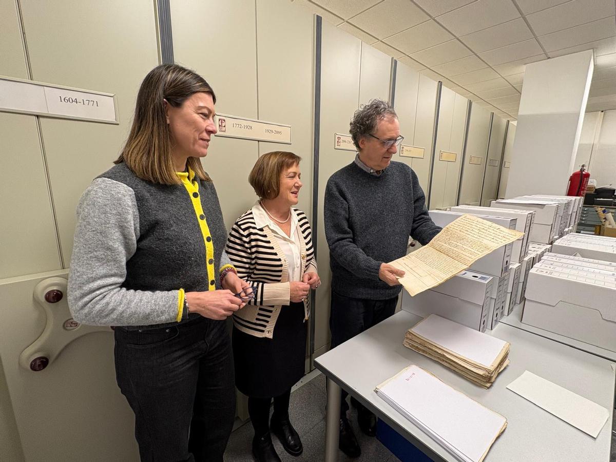 Por la izquierda, Marta Veiga, Mercedes Pérez y Juaco López con uno de los documentos en el archivo muncipal de Cangas del Narcea.