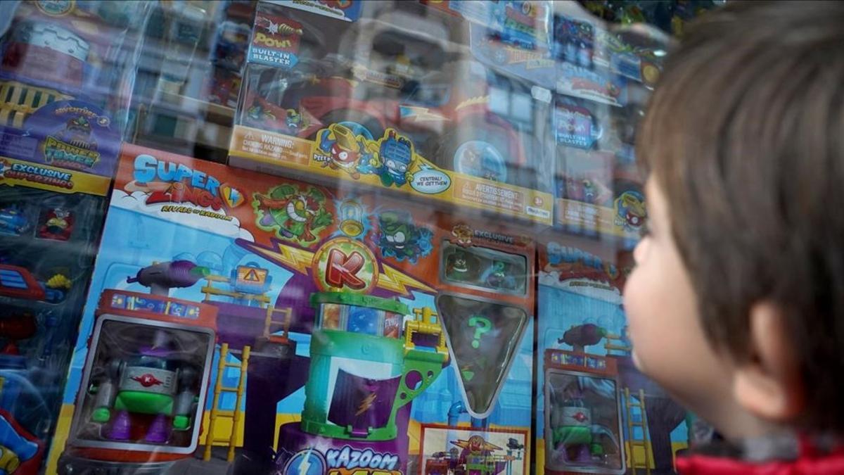 Un niño de cuatro observa el escaparate de una tienda de Madrid donde venden juguetes de Superzings