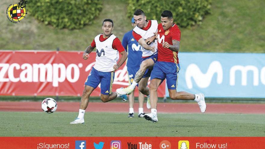 Iago Aspas golpea el balón, ayer, junto a Thiago Alcántara y a Vitolo, en el entrenamiento de la selección española. // @SeFutbol