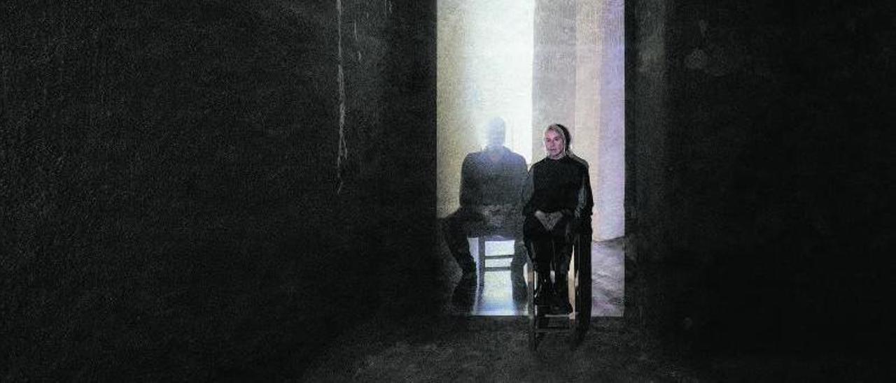 La artista visual Susy Gómez, sentada frente a una fotografía suya y de su compañero, Juan Antonio Horrach