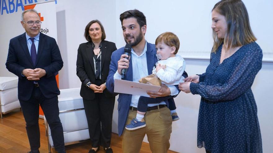 Aray Salvador Martín, de sólo un año, en brazos de su padre después de recibir el premio