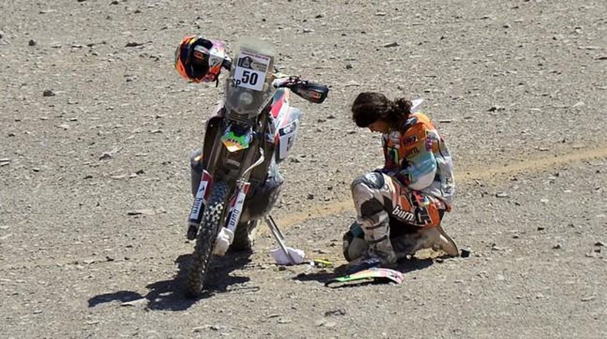 Laia Sanz repara la seva motocicleta durant la desena etapa del Dakar.