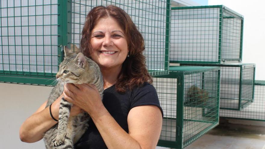 Isolina Rodríguez con uno de los gatos y junto a las terrazas de las jaulas.