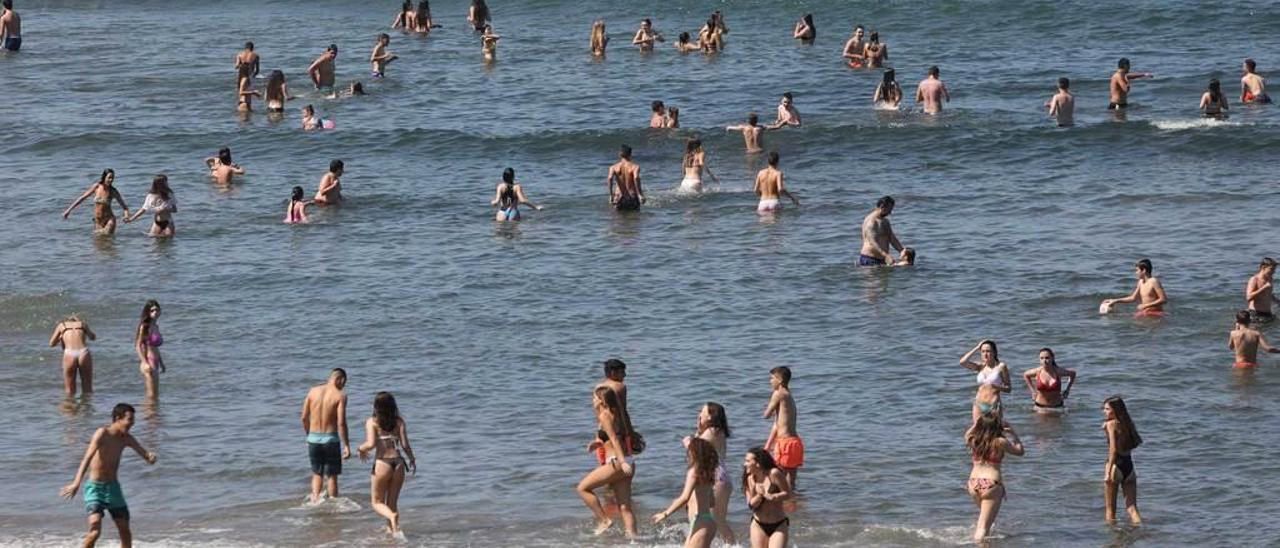 Gente bañándose ayer en la playa de Salinas.