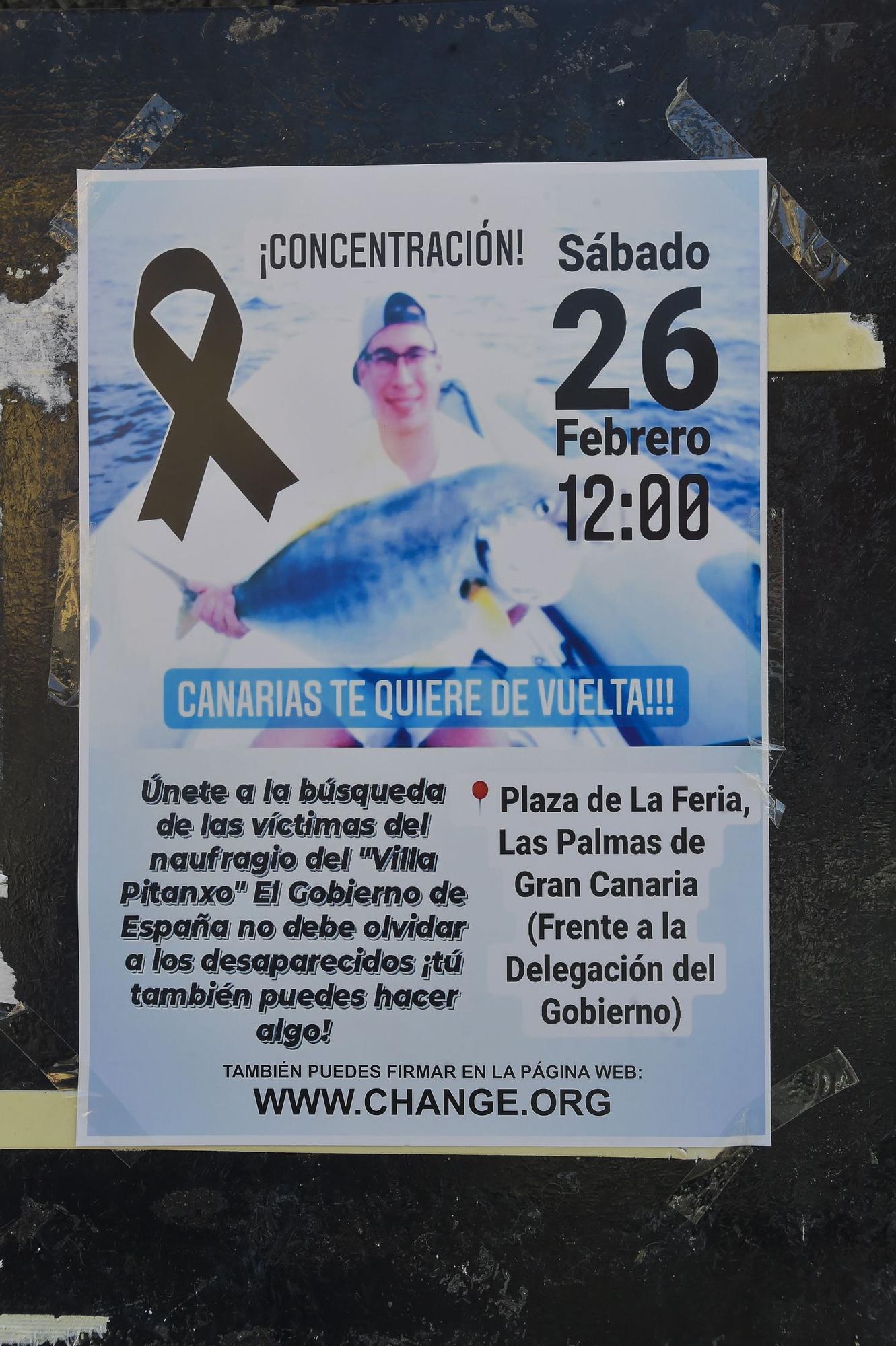 Pega de carteles para la concentración para seguir buscando al biólogo grancanario Manolín Navarro