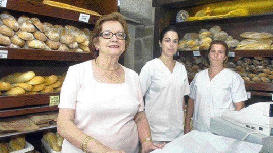 Isolina posa con su gente, familia y empleados, en su centenaria panadería. / CARLOS PEREIRA