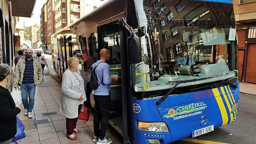 Viajeros acceden a un autobús urbano en La Felguera.