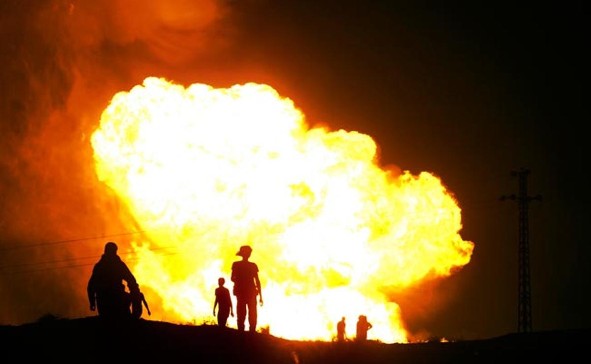 Beduïns egipcis observen l’incendi d’un gasoducte després d’un atemptat a Al-Arish, Egipte.