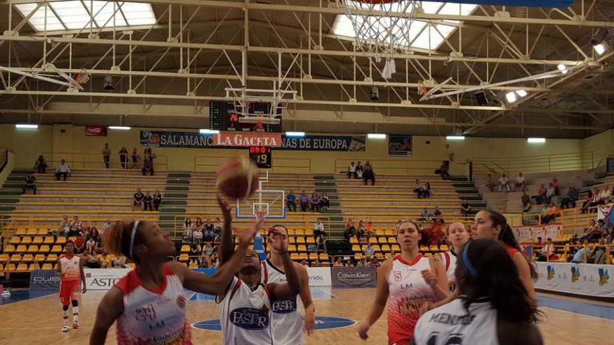 Starr Breedlove lanza a canasta entre varias jugadoras.