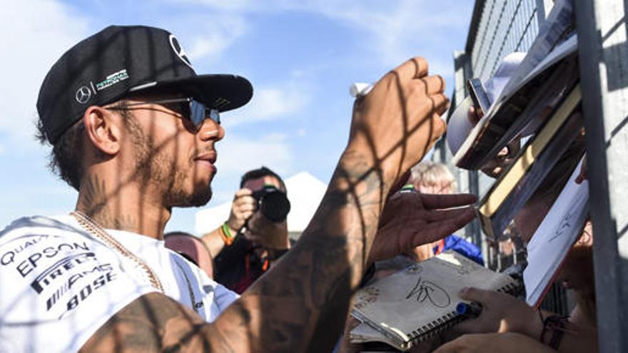 Lewis Hamilton firma autógrafos en el circuito de Hungría.