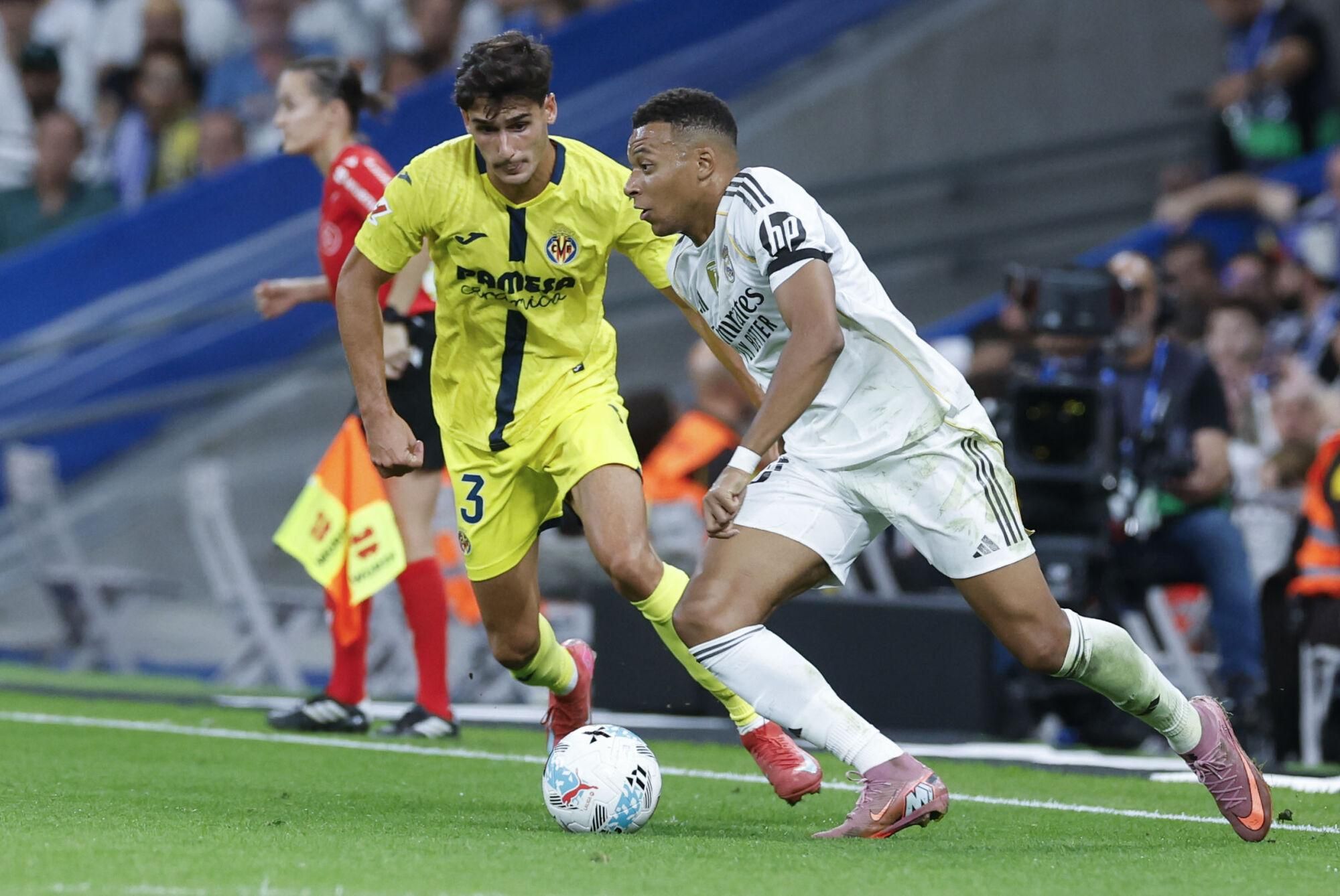 MADRID, 04/10/2025.- El delantero del Real Madrid Kylian Mbappé (d) juega un balón ante Sergi Cardona, del Villarreal, durante el partido de LaLiga de fútbol que Real Madrid y Villarreal disputan este sábado en el estadio Santiago Bernabéu. EFE/Javier Lizón
