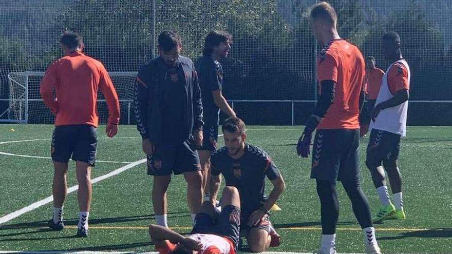 Javi López siendo atendido por el fisioterapeuta Manu Barros tras sufrir la lesión en su rodilla en el entrenamiento del lunes. // A. Davila