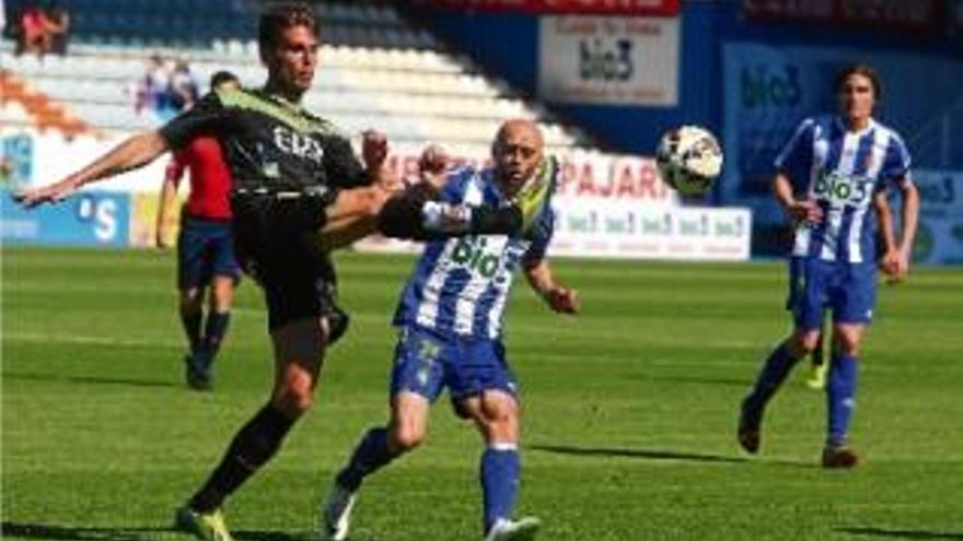 Pedro Alcalá rebutja una pilota davant Pablo Infante en la victòria del Llagostera a Ponferrada.