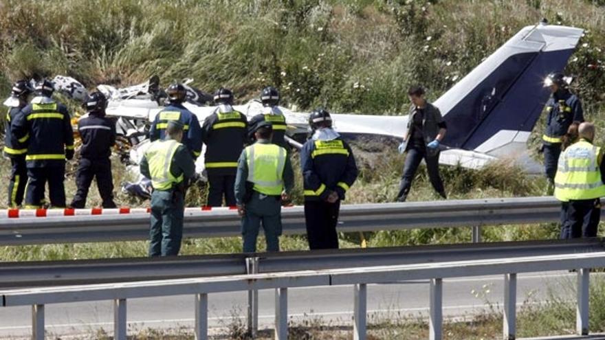 Bomberos y Guardia Civil junto a la avioneta de recreo que se estrelló hoy en Madrid