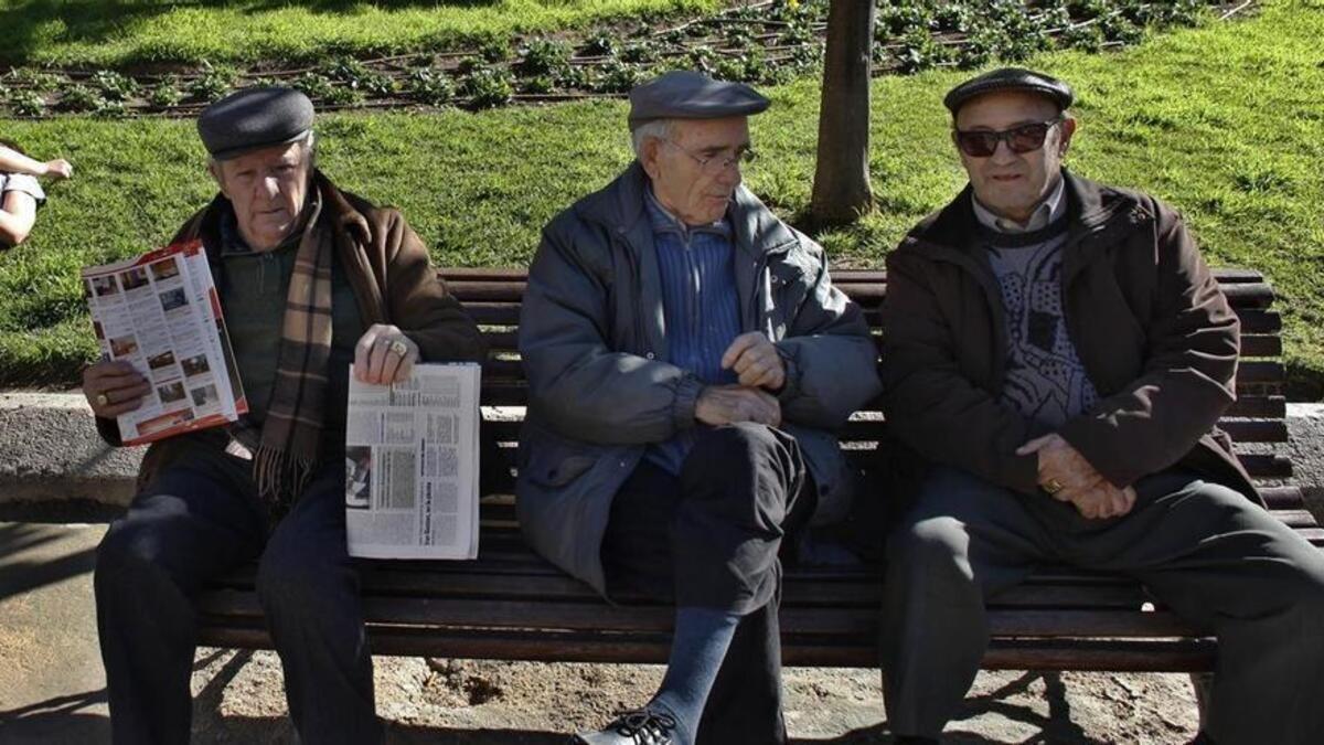 Tres jubilados, sentados en un banco.
