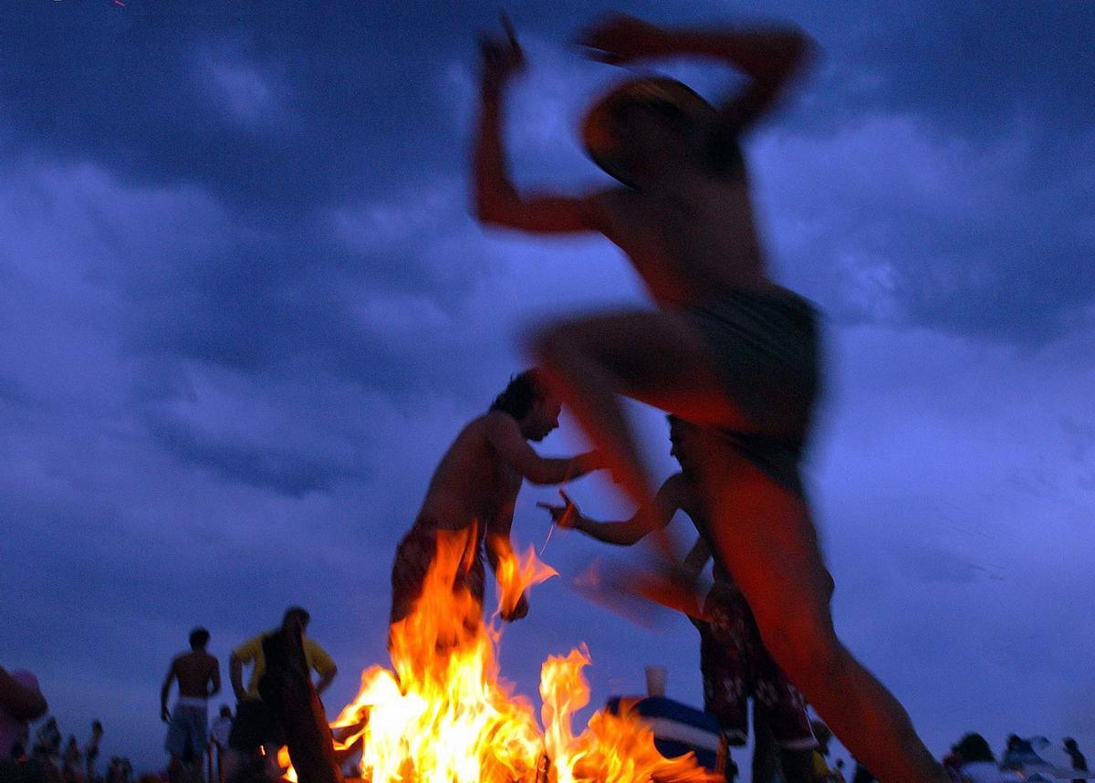 V.12. Valencia, 23/06/05. Un joven salta una de las decenas de hogueras que esta noche arden en la playa de Las Arenas y de la Malvarrosa de Valencia en la tradicional noche de San Juan. EFE/Manuel Bruque / HOGUERA