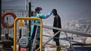 Un agente toma la temperatura a un joven recién llegado a Canarias.