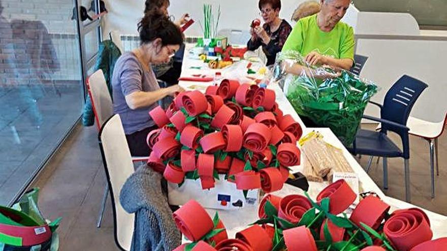 Els membres del casal preparant les roses amb goma EVA per a la campanya «Roses solidàries» d&#039;aquest any