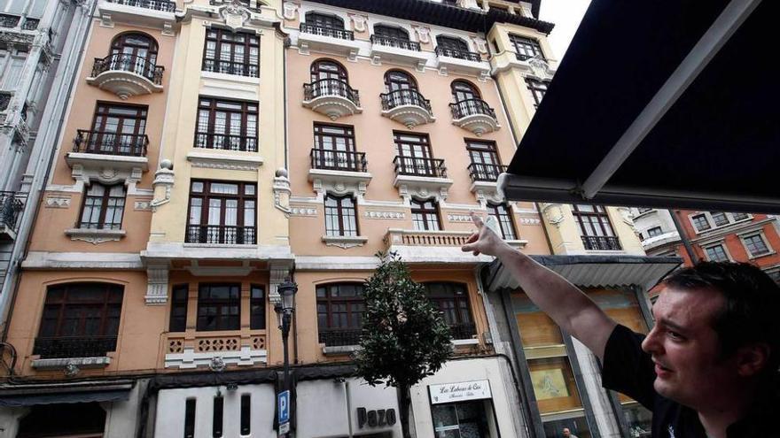 susto tras el desprendimiento. El desprendimiento de una cornisa causó ayer alarma entre los vecinos de la calle Independencia. En la imagen, uno de ellos señala la zona de donde cayeron cascotes.