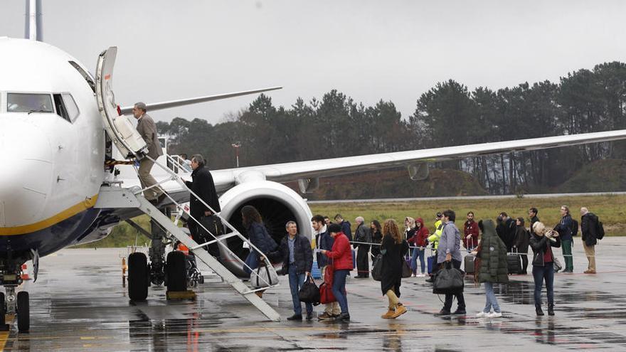 Pasajeros embarcan a un avión de Ryanair en el aeropuerto de Peinador. // J. Lores