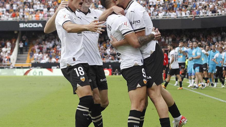 Los jugadores del Valencia felicitan a Hugo Duro tras marcar ante el Atlético. | FRANCISCO CALABUIG
